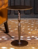 A close-up photo of the Forged Iron Accent Table showcasing its intricate hand-applied chiseled texture. The table is made entirely of iron with a rustic copper bronzed finish, exuding rugged elegance. The textured surface creates a visually captivating p