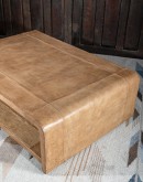 Modern rustic Sonora Sand Leather Coffee Table  featuring a rectangular shape with waterfall edge design, wrapped in fun grain saddle leather in palomino color. Includes a lower open shelf for storage or decoration.