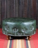 32'' round American-made Legends Cacti Ottoman upholstered in top grain green leather with hand burnished details, featuring nickel nail trim with cactus patterns around the base and a quilted diamond pattern on top.