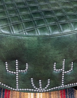 32'' round American-made Legends Cacti Ottoman upholstered in top grain green leather with hand burnished details, featuring nickel nail trim with cactus patterns around the base and a quilted diamond pattern on top.