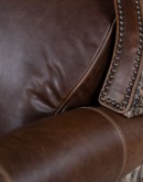 The Bronco Brindleback Recliner: A masterfully crafted, American-made recliner with a grand scale, bustle back, and supple light brown leather. Upholstery-grade brindle cowhide and gold-colored nail tacks add a touch of Western charm. Experience ultimate