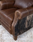 The Bronco Brindleback Recliner: A masterfully crafted, American-made recliner with a grand scale, bustle back, and supple light brown leather. Upholstery-grade brindle cowhide and gold-colored nail tacks add a touch of Western charm. Experience ultimate