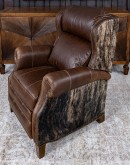The Bronco Brindleback Recliner: A masterfully crafted, American-made recliner with a grand scale, bustle back, and supple light brown leather. Upholstery-grade brindle cowhide and gold-colored nail tacks add a touch of Western charm. Experience ultimate