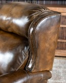 A luxurious Bronco Beretta Leather Recliner in rich brown top grain leather, featuring hand-burnished details, brass nail tacks, leather welting, and a bustleback design for optimal head and neck support.