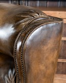 A luxurious Bronco Beretta Leather Recliner in rich brown top grain leather, featuring hand-burnished details, brass nail tacks, leather welting, and a bustleback design for optimal head and neck support.