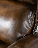 A luxurious Bronco Beretta Leather Recliner in rich brown top grain leather, featuring hand-burnished details, brass nail tacks, leather welting, and a bustleback design for optimal head and neck support.