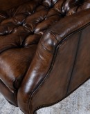 distressed leather recliner with button tufting on seat and back