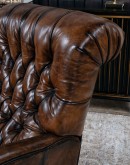 distressed leather recliner with button tufting on seat and back