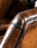 distressed leather recliner with button tufting on seat and back