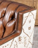 swivel chair with dark tufted leather on inside and southwestern style fabric on outside