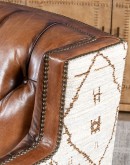 swivel chair with dark tufted leather on inside and southwestern style fabric on outside