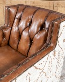 swivel chair with dark tufted leather on inside and southwestern style fabric on outside