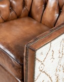 swivel chair with dark tufted leather on inside and southwestern style fabric on outside