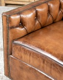 swivel chair with dark tufted leather on inside and southwestern style fabric on outside