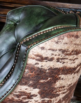 swivel and rocker chair with tufted green leather and cowhide on the outside