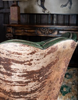 swivel and rocker chair with tufted green leather and cowhide on the outside