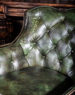 swivel and rocker chair with tufted green leather and cowhide on the outside