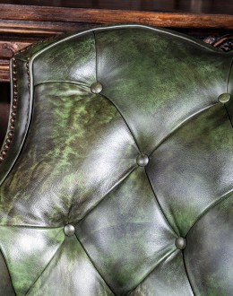 swivel and rocker chair with tufted green leather and cowhide on the outside