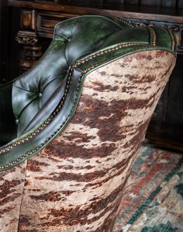 swivel and rocker chair with tufted green leather and cowhide on the outside