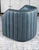 A luxurious slate blue barrel swivel chair with full-grain leather, padded channeling, brass nail tacks, and 8-way hand-tied construction, part of Adobe Interiors' Coastal Ranch Collection.