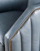 A luxurious slate blue barrel swivel chair with full-grain leather, padded channeling, brass nail tacks, and 8-way hand-tied construction, part of Adobe Interiors' Coastal Ranch Collection.