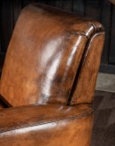 Speakeasy Swivel Chair, a 100% American-made, luxurious full-grain leather chair with a timeless, low-profile design featuring a tufted back, spring down seat cushion, and hand burnished leather accents