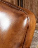 high end Leather Swivel Chair in rich saddle leather, featuring pleated stitched channels, brass nail tacks, and large flat armrests for exceptional comfort.