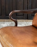 executive desk chair in distressed tan saddle leather with boot stitch design on seat back