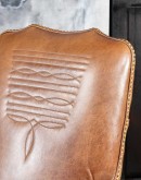 executive desk chair in distressed tan saddle leather with boot stitch design on seat back