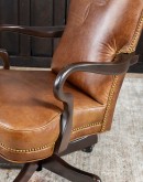 executive desk chair in distressed tan saddle leather with boot stitch design on seat back