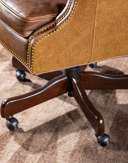 True Grit Executive Desk Chair in full-grain brown leather with gold-finish brass nail tacks and leather suede sides, showcasing ergonomic wingback design for superior comfort.