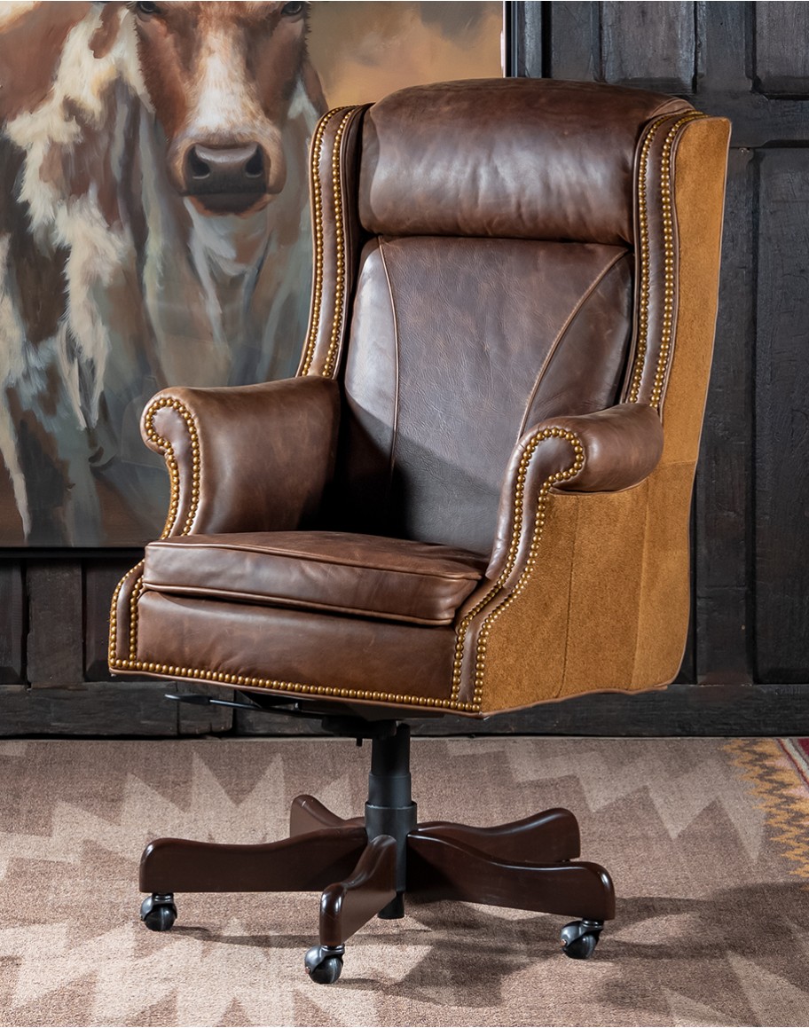 True Grit Executive Desk Chair in full-grain brown leather with gold-finish brass nail tacks and leather suede sides, showcasing ergonomic wingback design for superior comfort.
