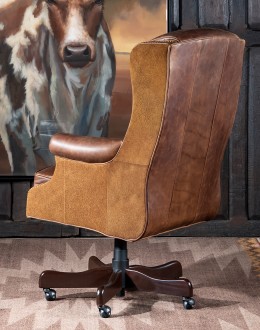True Grit Executive Desk Chair in full-grain brown leather with gold-finish brass nail tacks and leather suede sides, showcasing ergonomic wingback design for superior comfort.