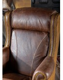 True Grit Executive Desk Chair in full-grain brown leather with gold-finish brass nail tacks and leather suede sides, showcasing ergonomic wingback design for superior comfort.