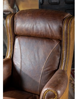 True Grit Executive Desk Chair in full-grain brown leather with gold-finish brass nail tacks and leather suede sides, showcasing ergonomic wingback design for superior comfort.